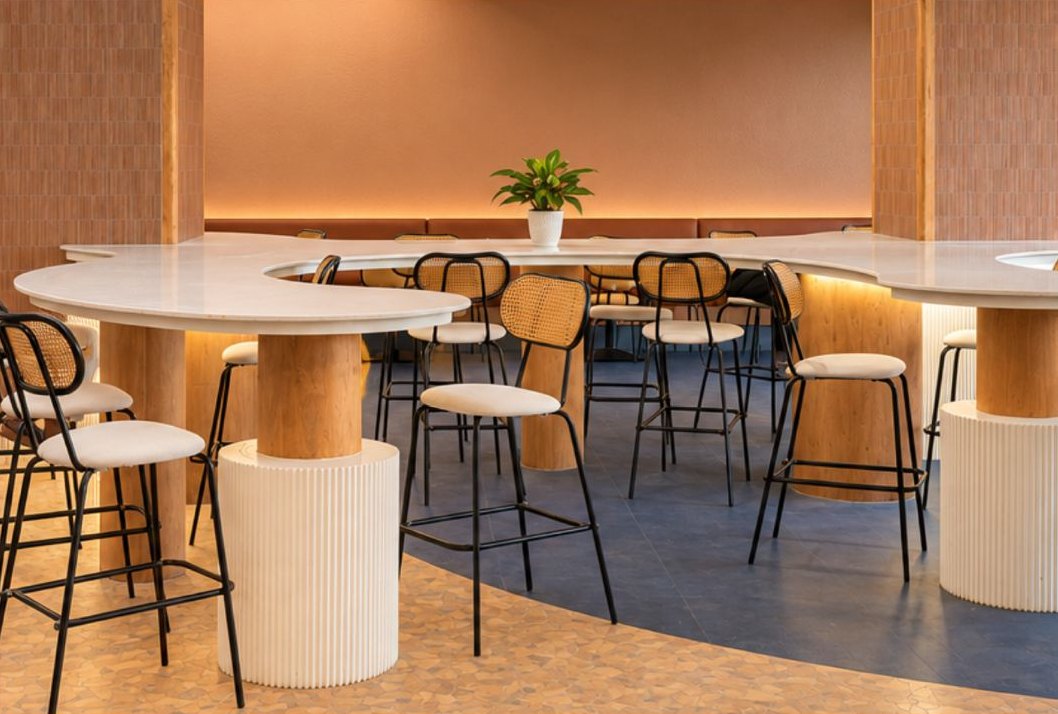 Café with a curved counter and rattan bar chairs
