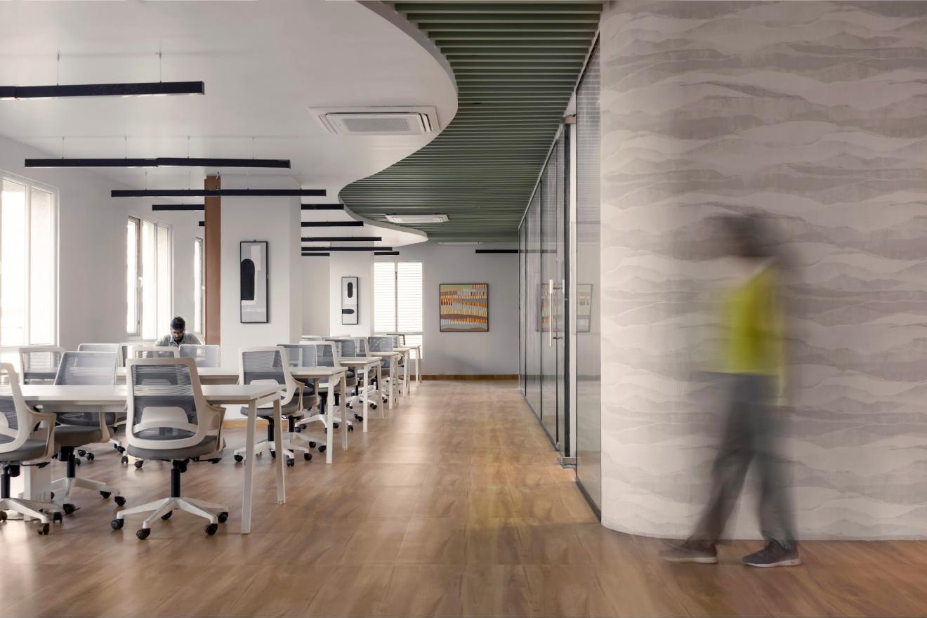 Open workstations along a wood floor and curved ceiling