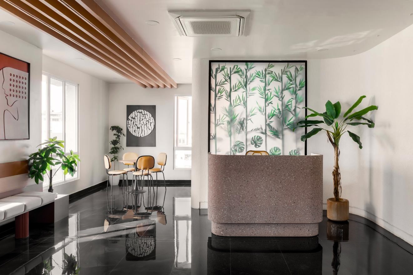 Reception with a terrazzo desk, plants and lounge seating